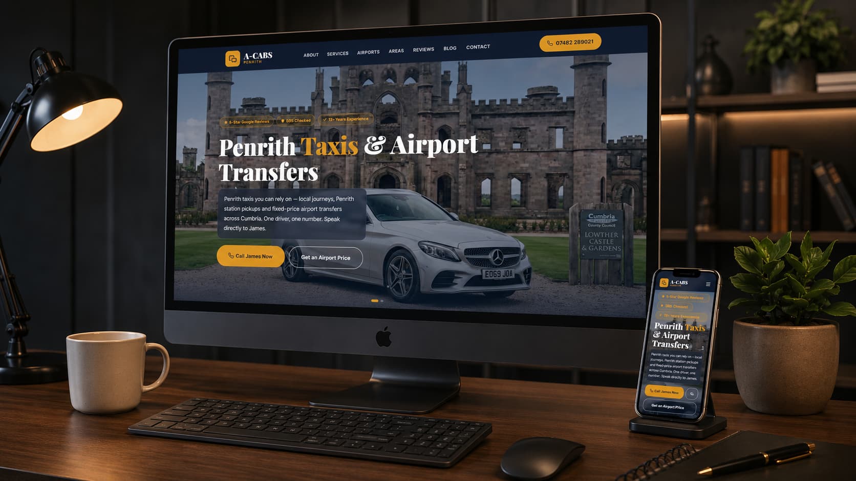 A-CABS Penrith taxi website shown on a desktop monitor and phone in a home office