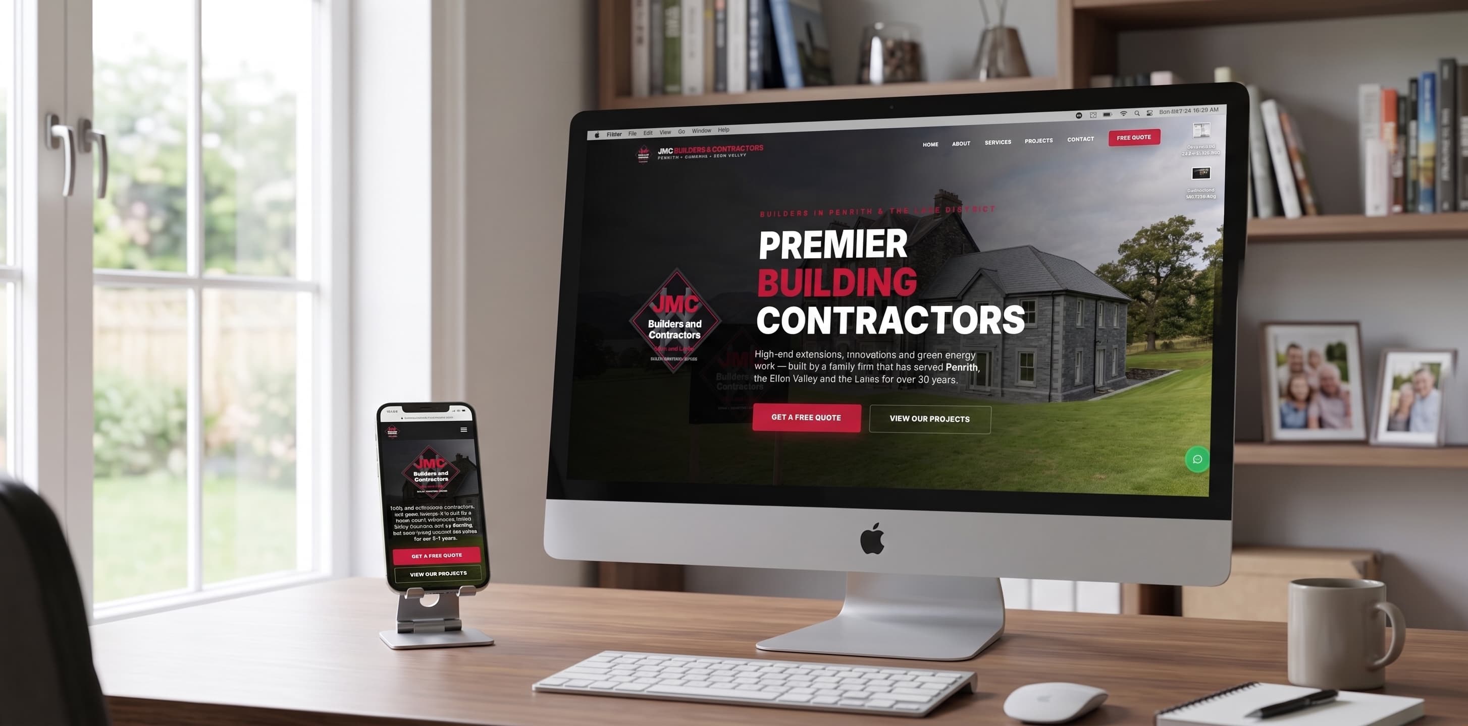 JMC Builders & Contractors website shown on a desktop monitor and phone in a home office